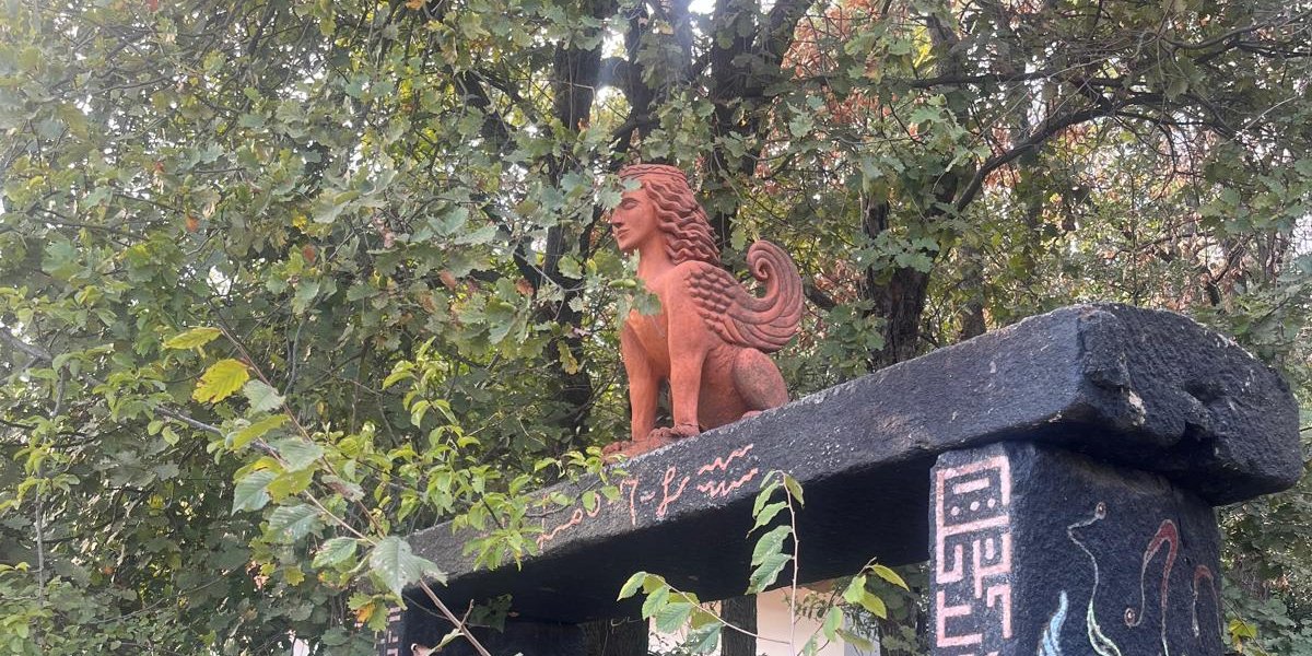 Steintor mit Sphinx und alten Zeichen im Grünen
